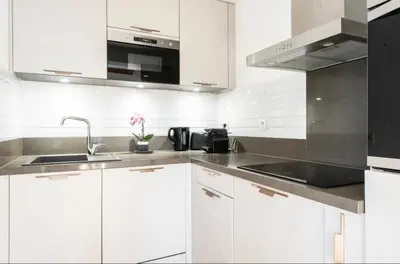 a white kitchen with a sink and a microwave at Mont Blanc 25, vue Mont blanc, balcon, parking in Chamonix-Mont-Blanc