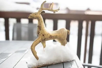 a statue of a reindeer sitting on top of a table at Mont Blanc 25, vue Mont blanc, balcon, parking in Chamonix-Mont-Blanc