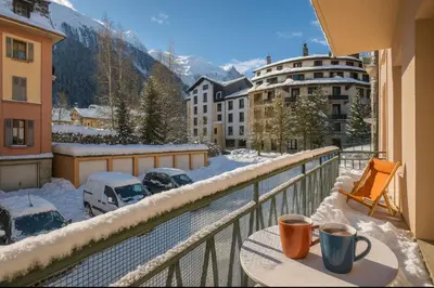 a balcony with two cups of coffee on a table in the snow at Warm Haven in Chamonix With balcony in Chamonix-Mont-Blanc