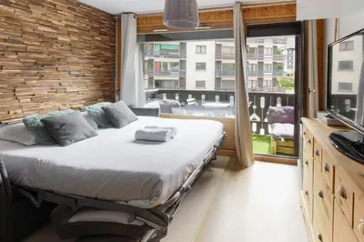 a bedroom with a bed and a large window at Les Dryades - Rénové - Balcon avec vue Mt Blanc in Les Houches
