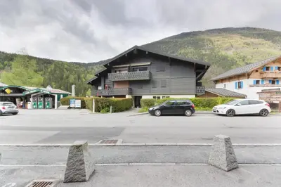 a building with cars parked in a parking lot at Les Dryades - Rénové - Balcon avec vue Mt Blanc in Les Houches