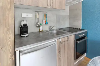 a small kitchen with a sink and a stove at Les Dryades - Rénové - Balcon avec vue Mt Blanc in Les Houches