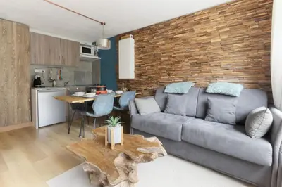 a living room with a couch and a table at Les Dryades - Rénové - Balcon avec vue Mt Blanc in Les Houches