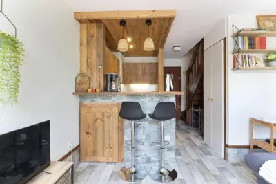 a kitchen with a counter and stools in a room at Le Crêtet Mont-Blanc in Chamonix-Mont-Blanc