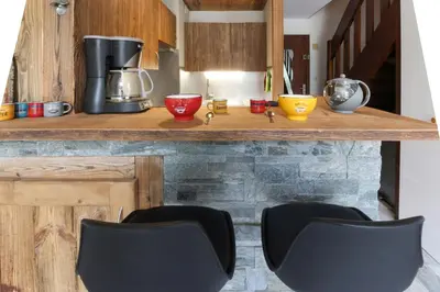 a counter with two black chairs in a kitchen at Le Crêtet Mont-Blanc in Chamonix-Mont-Blanc