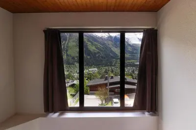a window with a view of a mountain at Le Crêtet Mont-Blanc in Chamonix-Mont-Blanc