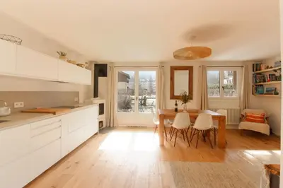 a kitchen with a wooden table and a dining room at Les Gaillands in Chamonix-Mont-Blanc