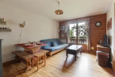 a living room with a blue couch and a table at Les Capucins - Calm - Mont-Blanc - Lake Gaillland in Chamonix-Mont-Blanc