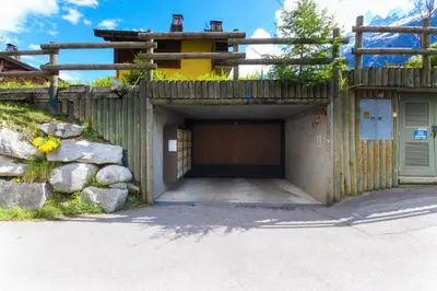 a building with a garage with a fence at Les Capucins - Calm - Mont-Blanc - Lake Gaillland in Chamonix-Mont-Blanc