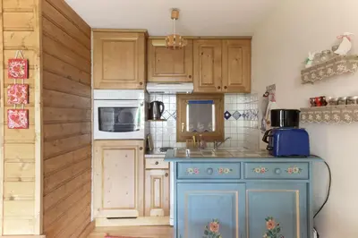 a kitchen with wooden cabinets and a blue island at Les Capucins - Calm - Mont-Blanc - Lake Gaillland in Chamonix-Mont-Blanc