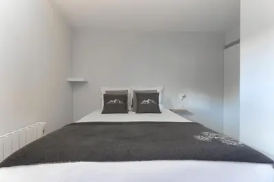 a bedroom with a large white bed with two pillows at Le Jardin de Champraz in Chamonix-Mont-Blanc