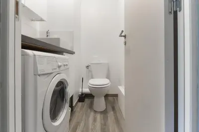 a bathroom with a toilet and a washing machine at Le Jardin de Champraz in Chamonix-Mont-Blanc