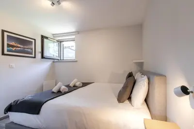 a bedroom with a large white bed with two pillows at Le Jardin de Champraz in Chamonix-Mont-Blanc