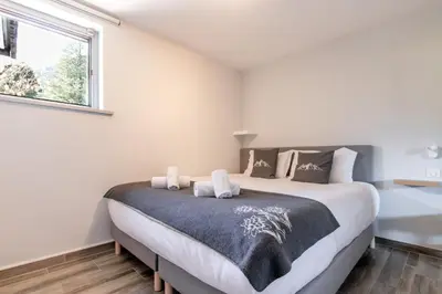 a bedroom with a large bed with a window at Le Jardin de Champraz in Chamonix-Mont-Blanc