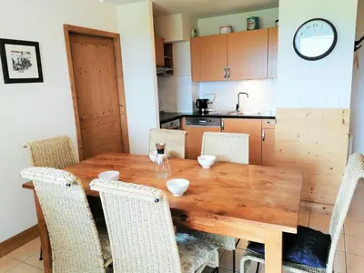 a kitchen with a wooden table and chairs at T4 à Morillon 1100 avec Wifi et Animaux acceptés - FR-1-815-79 in Morillon