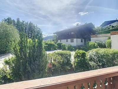 a balcony with a view of a yard with bushes at Appartement 2 pièces + cabine à proximité du village et téléski, cuisine équipée - FR-1-560-89 in Combloux