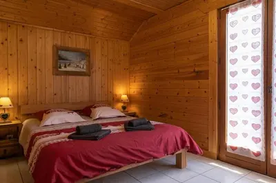 a bedroom with a bed in a wooden room at Appartement l'éterlou in Sallanches