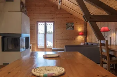two pizzas sitting on a wooden table in a room at Appartement l'éterlou in Sallanches