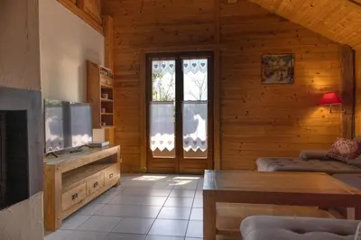 a living room with a fireplace in a log cabin at Appartement l'éterlou in Sallanches