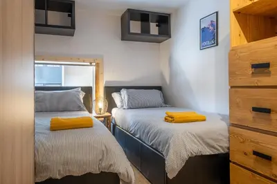 a bedroom with two beds with yellow towels on them at Grand Roc A - 3 bedrooms Apartment Next to skilift - By Cozee Rentals in Chamonix-Mont-Blanc
