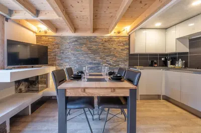 a dining room with a wooden table and chairs at Grand Roc A - 3 bedrooms Apartment Next to skilift - By Cozee Rentals in Chamonix-Mont-Blanc