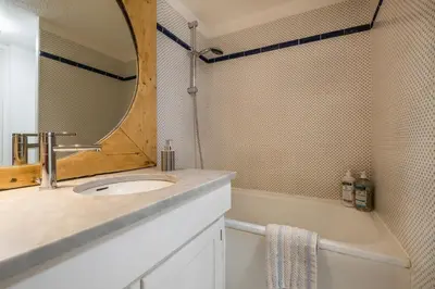 a bathroom with a sink and a mirror and a tub at Grand Roc A - 3 bedrooms Apartment Next to skilift - By Cozee Rentals in Chamonix-Mont-Blanc