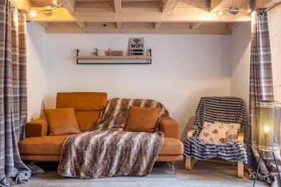 a living room with a couch and a chair at Grand Roc A - 3 bedrooms Apartment Next to skilift - By Cozee Rentals in Chamonix-Mont-Blanc