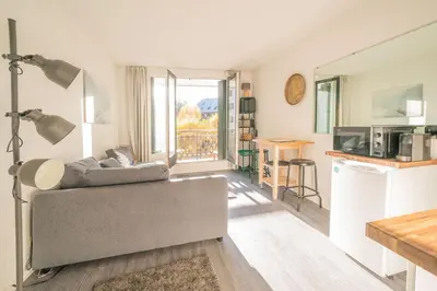 a living room with a couch and a kitchen at Chamonix Sud studio with Mont Blanc views in Chamonix-Mont-Blanc
