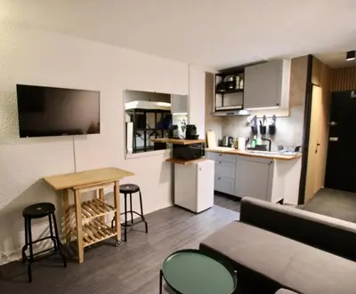 a living room with a couch and a table and a kitchen at Chamonix Sud studio with Mont Blanc views in Chamonix-Mont-Blanc