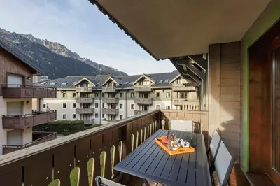 a table on a balcony with a view of buildings at Grepon -City Center - Free Swimming pool, Sauna, Gym - Free Parking - By Cozee Rentals in Chamonix-Mont-Blanc