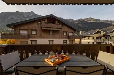 a table on a balcony with a view of a building at Grepon -City Center - Free Swimming pool, Sauna, Gym - Free Parking - By Cozee Rentals in Chamonix-Mont-Blanc