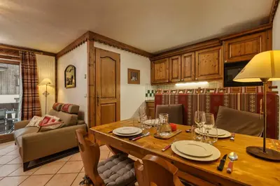 a dining room with a table and a living room at Grepon -City Center - Free Swimming pool, Sauna, Gym - Free Parking - By Cozee Rentals in Chamonix-Mont-Blanc