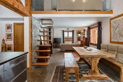 a kitchen and living room with a wooden table at Chalet Fleur de Lys - Chalet 4BR Wood Stove , Home Cinema , Parental Suite - By Cozee Rentals in Les Houches