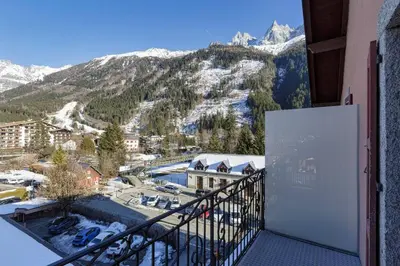 a balcony with a view of a snow covered mountain at Epicea - Chic 2BR in city center, next to Train Station - By Cozee Rentals in Chamonix-Mont-Blanc