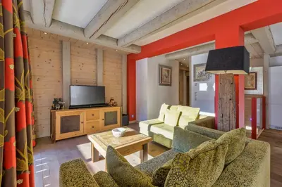 a living room with a couch and a tv at La Blaitière - Luxe Apart Center Chamonix , Next to Piste Planard - By Cozee Rentals in Chamonix-Mont-Blanc