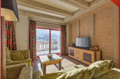 a living room with a couch and a television at La Blaitière - Luxe Apart Center Chamonix , Next to Piste Planard - By Cozee Rentals in Chamonix-Mont-Blanc