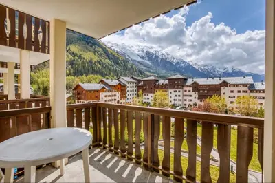 a balcony with a table and a view of mountains at Nice Apt With Balcon In The Downtown ! in Chamonix-Mont-Blanc