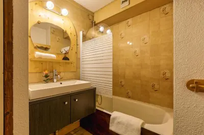 a bathroom with a sink and a tub and a mirror at Appartement Central Des Houches - 15 - Happy Rentals in Les Houches