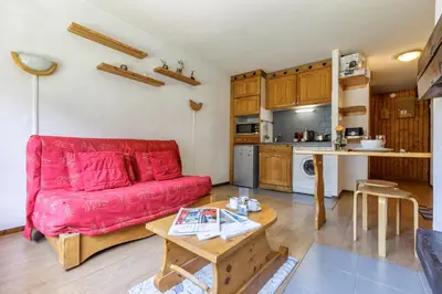 a living room with a red couch and a table at Appartement Central Des Houches - 15 - Happy Rentals in Les Houches