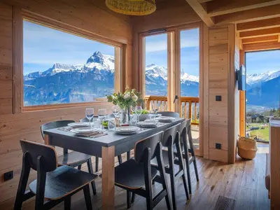 a dining room with a table and some mountains at Chalet Fanfoua - OVO Network in Combloux