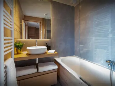 a bathroom with a sink and a tub and a mirror at Chalet Fanfoua - OVO Network in Combloux