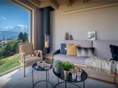 a living room with a couch and a large window at Chalet Fanfoua - OVO Network in Combloux