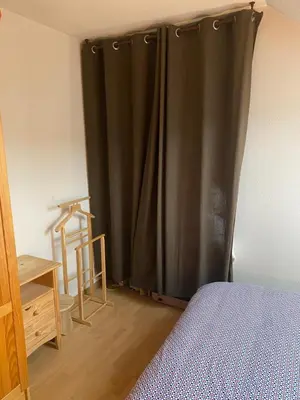 a bedroom with a black curtain next to a bed at Duplex Samoëns 4/6 couchages in Samoëns