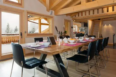 a dining room with a large wooden table and chairs at Chalet Isabelle Mountain lodge 5 star 5 bedroom en suite sauna jacuzzi in Chamonix-Mont-Blanc