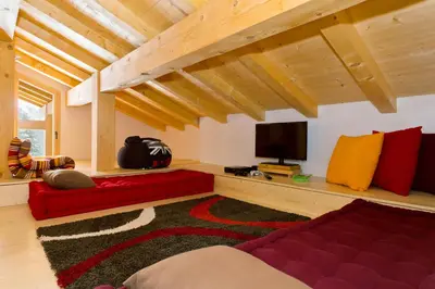 a living room with a red couch and a flat screen tv at Chalet Isabelle Mountain lodge 5 star 5 bedroom en suite sauna jacuzzi in Chamonix-Mont-Blanc