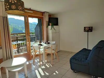 a living room with a table and a couch at Studio & piscine intérieure, vue Mont D'Arbois in Saint-Gervais-les-Bains