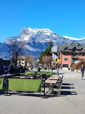 a table and chairs with a mountain in the background at Studio & piscine intérieure, vue Mont D'Arbois in Saint-Gervais-les-Bains