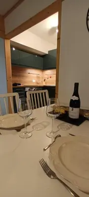 a table with glasses and a bottle of wine on it at Le Flory'lège in Saint-Gervais-les-Bains