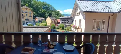 a table on a balcony with a view of a street at Le Flory'lège in Saint-Gervais-les-Bains