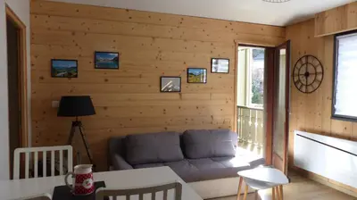 a living room with a couch in a wooden wall at Le Flory'lège in Saint-Gervais-les-Bains